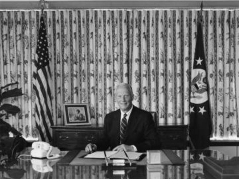 John Louis sat behind a large desk