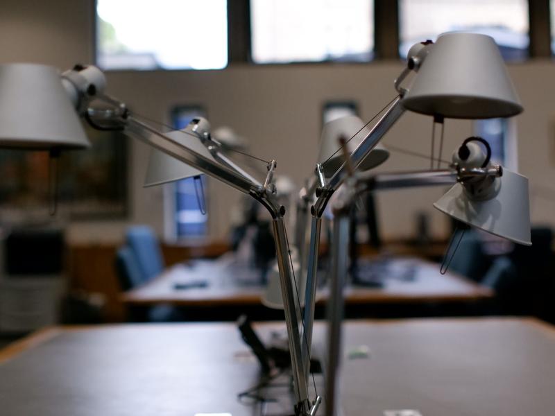 two silver metallic lamps on a desk