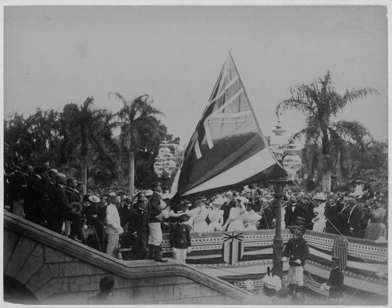Frank Davey, Public domain, via Wikimedia Commons {{PD-US}} (https://upload.wikimedia.org/wikipedia/commons/5/5b/Lowering_the_Hawaiian_flag_at_Annexation_ceremony_%28PPWD-8-3-006%29.jpg)